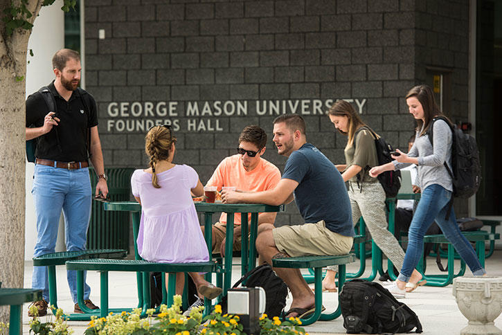 Students sit outside Founders Hall at Mason Arlington Campus