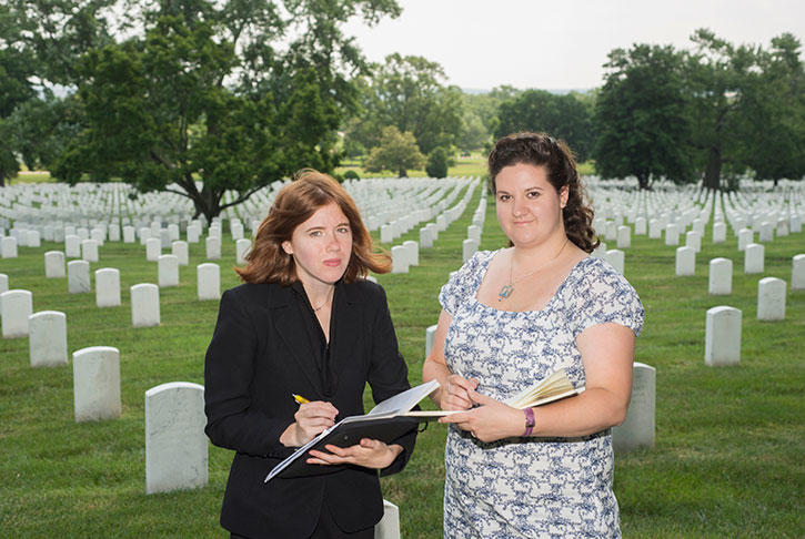 Two Mason students at Arlington National Cemetery in front of headstones