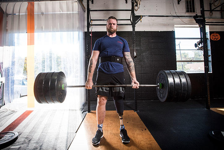 Jason Sturm lifts weights in a Mason gym